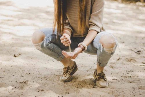 girl pouring sand in her hand like depth psychotherapy